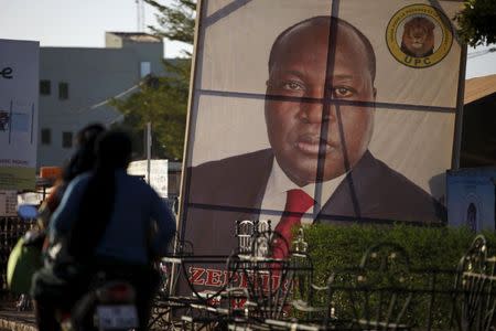 People ride a motorcycle past a billboard for presidential candidate Zephirin Diabre in Ouagadougou, Burkina Faso, November 28, 2015, ahead of the election. REUTERS/Joe Penney