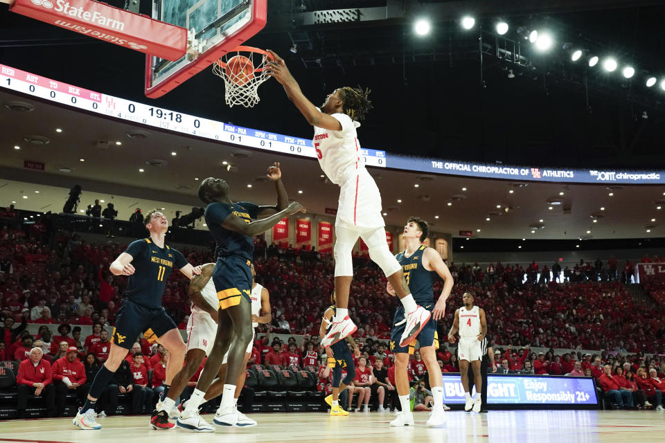 Houston forward Ja'Vier Francis, top right, dunks over West Virginia forward Akok Akok, second from bottom left, during the first half of an NCAA college basketball game Saturday Jan. 6, 2024, in Houston. (AP Photo/Eric Christian Smith)