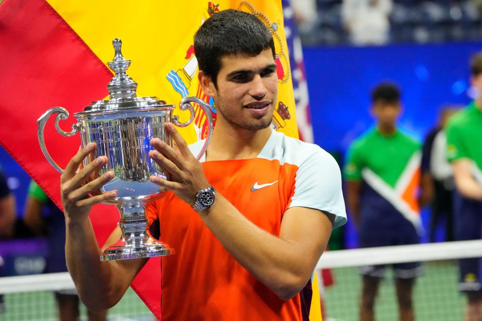 Carlos Alcaraz celebrates with the championship trophy after his match against Casper Ruud.