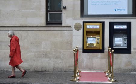 A woman walks past a golden ATM, marking the location of the first 'hole in the wall,' which opened fifty years ago, in Enfield, Britain June 27, 2017. REUTERS/Hannah McKay