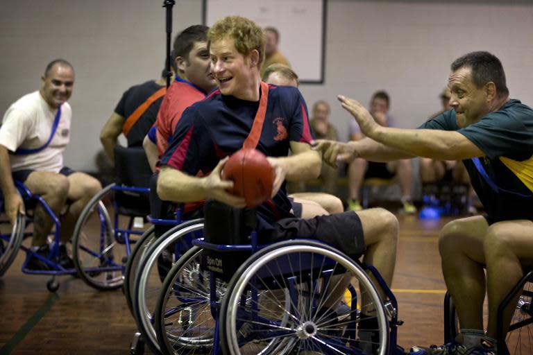 In this undated photograph received on April 18, 2015, from the Australian Defence department, Britain's Prince Harry (C) dodges a tackle as he plays wheelchair AFL with members of the Soldier Recover Centre at Robertson Barracks in Darwin, Australia