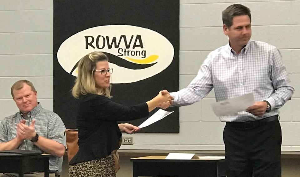 ROWVA School Board Vice President Scott Lake shakes the hand of new board member Amber Fleming March 21 while John Kuelper applauds the appointment. Emails show Lake recommended "The Hate U Give" be suspended from use in the classroom.