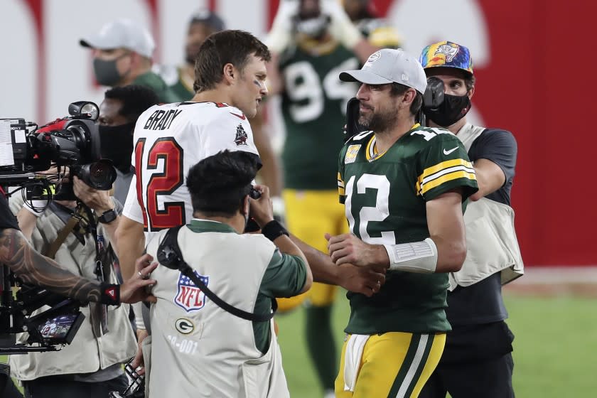 Tampa Bay Buccaneers quarterback Tom Brady, left, shakes hands with Green Bay Packers quarterback Aaron Rodgers.