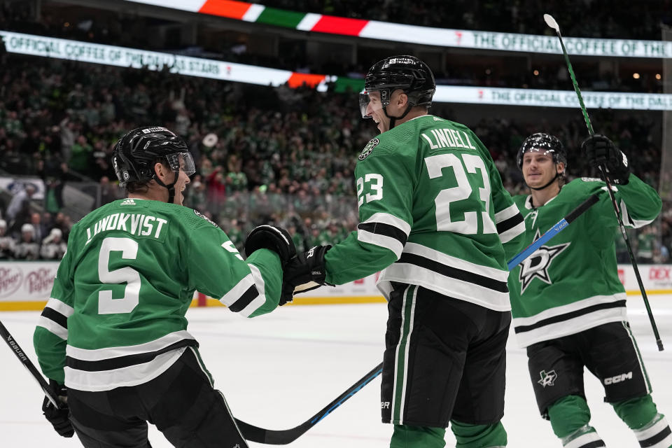 Dallas Stars' Nils Lundkvist (5), Esa Lindell (23) and Roope Hintz, right, celebrate after Lindell scored against the Arizona Coyotes in the first period of an NHL hockey game, Tuesday, Nov. 14, 2023, in Dallas. Lundkvist had an assists on the score. (AP Photo/Tony Gutierrez)