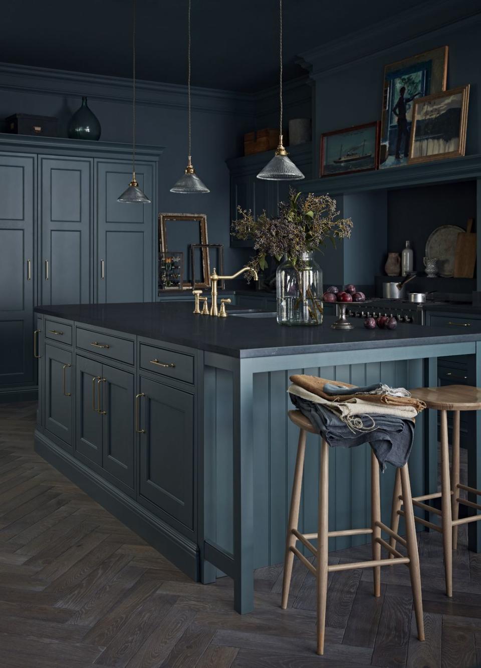 dark kitchen island with herringbone wooden flooring