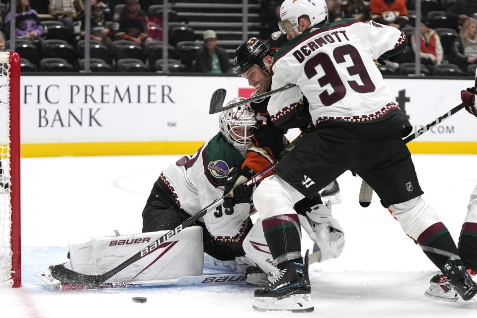 Anaheim Ducks forward Zack Kassian, center, tries to get a shot past Arizona Coyotes goaltender Connor Ingram, left, while defenseman Travis Dermott defends during the first period of a preseason NHL hockey game Thursday, Oct. 5, 2023, in Anaheim, Calif. (AP Photo/Mark J. Terrill)