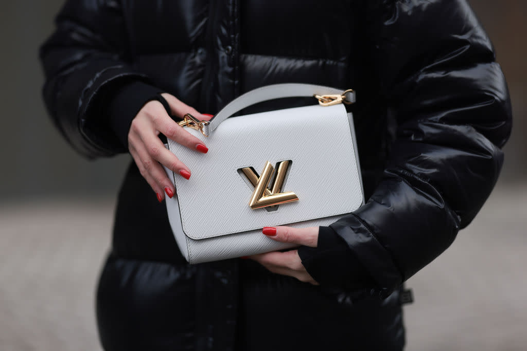 A model in Berlin, Germany, wears an Aritzia black shiny puffer nylon hooded long winter coat while holding a Louis Vuitton white leather Twist bag on January 15, 2024. (Photo by Jeremy Moeller/Getty Images)