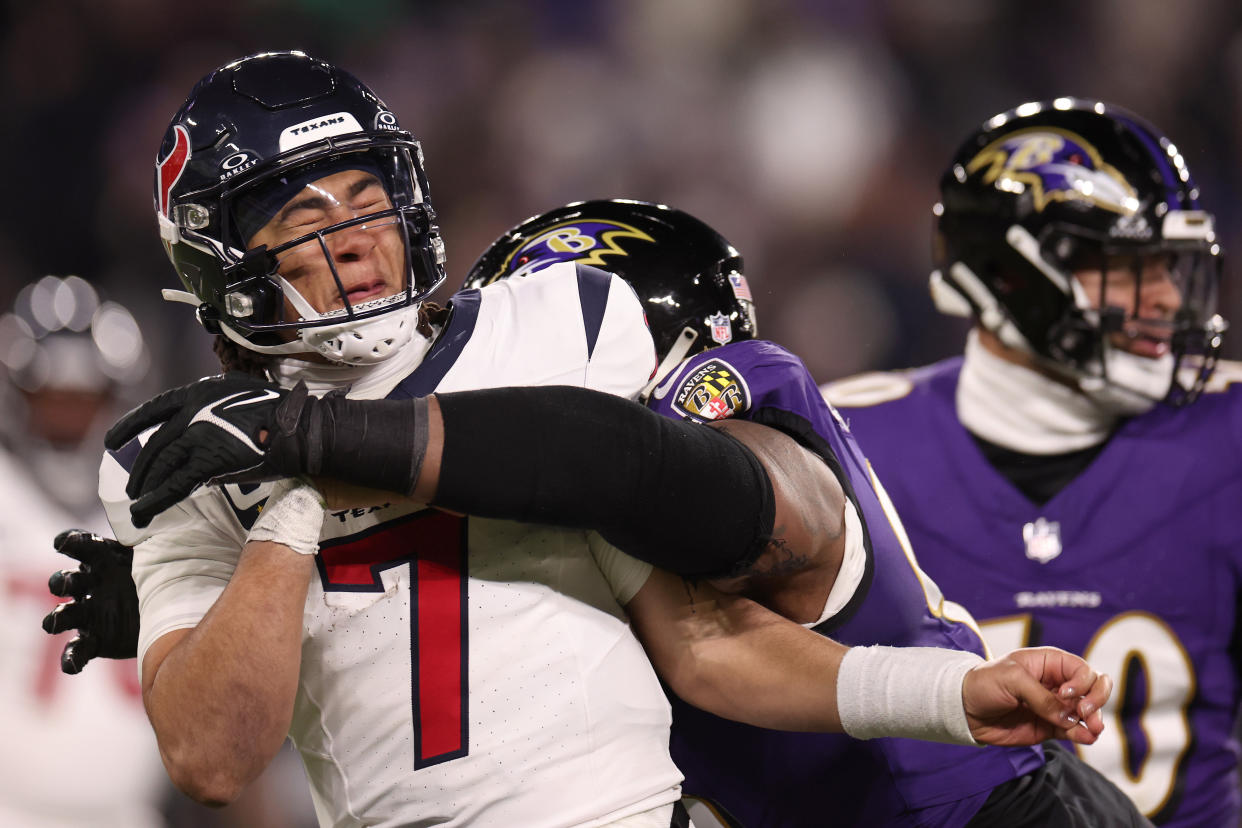 Broderick Washington of the Baltimore Ravens wraps up C.J. Stroud of the Houston Texans in a divisional round playoff game. (Photo by Rob Carr/Getty Images)