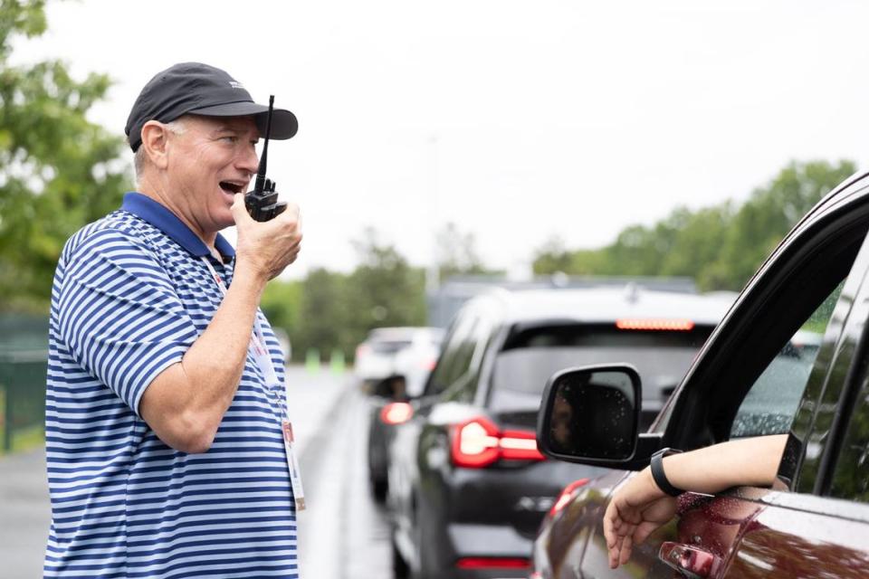 An employee uses a radio to call a volunteers name during uniform distribution before the Wells Fargo Championship at Quail Hollow Club in Charlotte, NC on May 4, 2024. Isaiah Vazquez/Special to The Charlotte Observe