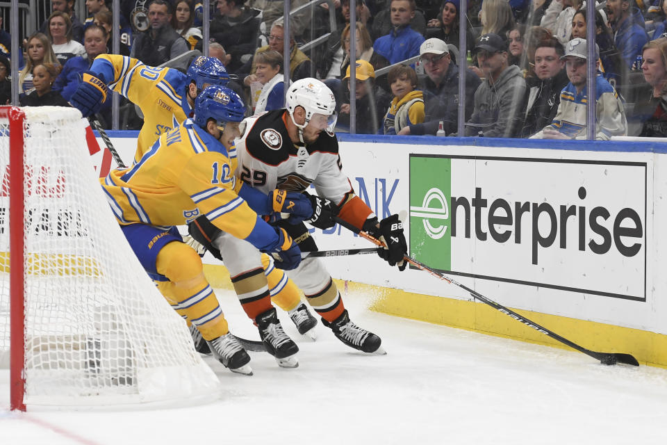 Anaheim Ducks' Dmitry Kulikov (29) fights against St. Louis Blues' Brayden Schenn (10) for the puck during the second period of an NHL hockey game Monday, Nov. 21, 2022, in St. Louis. (AP Photo/Michael Thomas)