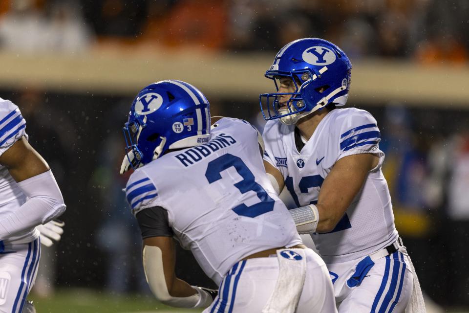 BYU quarterback Jake Retzlaff (12) hands the ball off to running back Aidan Robbins (3) during the second half of the team’s NCAA college football game against Oklahoma State on Saturday, Nov. 25, 2023, in Stillwater, Okla. | Mitch Alcala, Associated Press
