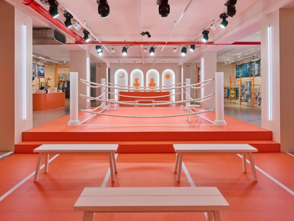 Sleek orange boxing arena inside a Hermèsfit pop-up gym.