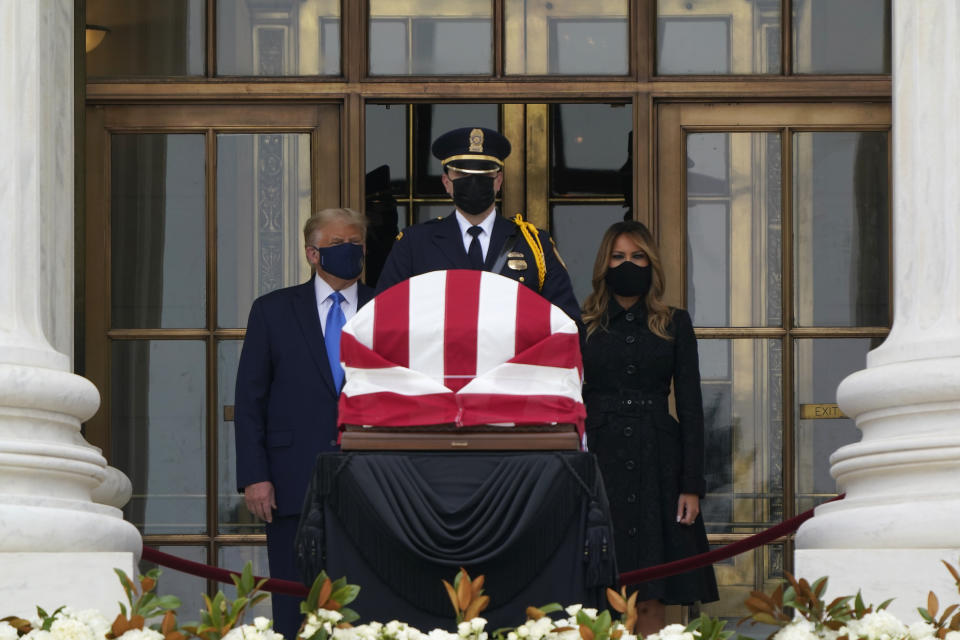 President Donald Trump turns to his left as protesters yell from a block away while he and first lady Melania Trump pay respects as Justice Ruth Bader Ginsburg lies in repose at the Supreme Court building on Thursday, Sept. 24, 2020, in Washington. Ginsburg, 87, died of cancer on Sept. 18. (AP Photo/J. Scott Applewhite)