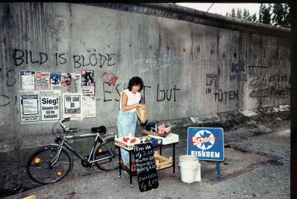 <p>Puesto de venta de productos de una mujer junto al muro de Berlín. (Photo by Thierlein/ullstein bild via Getty Images)</p> 