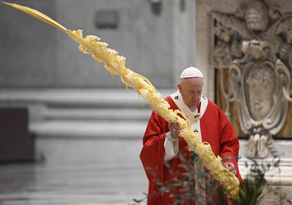 El papa Francisco sostiene una rama de palma mientras celebra la misa del Domingo de Ramos en una Basílica de San Pedro vacía, en el Vaticano, el domingo 5 de abril de 2020. (AP Foto/pool/Alberto Pizzoli)