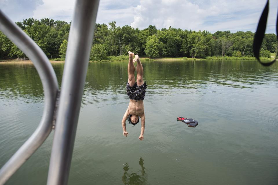 Burn camp participant Isaac "Jiantal" Taylor, 17, of Fairland, dives into the water from the top deck of the party pontoon boat during a two day camping trip for teen participants of the Hoosier Burn Camp at Lake Monroe in Bloomington, Ind., July 20, 2016. Chris Howell | Herald-Times 