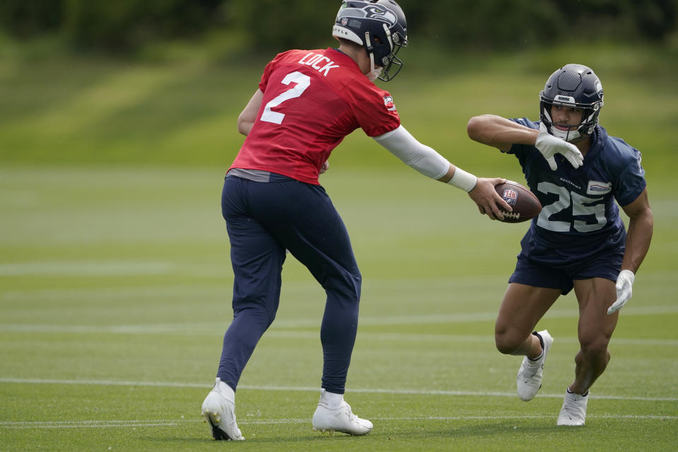 Seattle Seahawks quarterback Drew Lock (2) hands off to running back Travis Homer during NFL football practice Wednesday, June 8, 2022, in Renton, Wash. (AP Photo/Ted S. Warren)