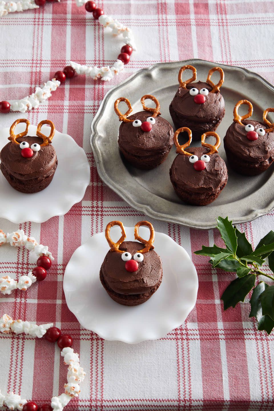 brownies cut into rounds topped with icing and decorated to look like a reindeer with pretzel antlers