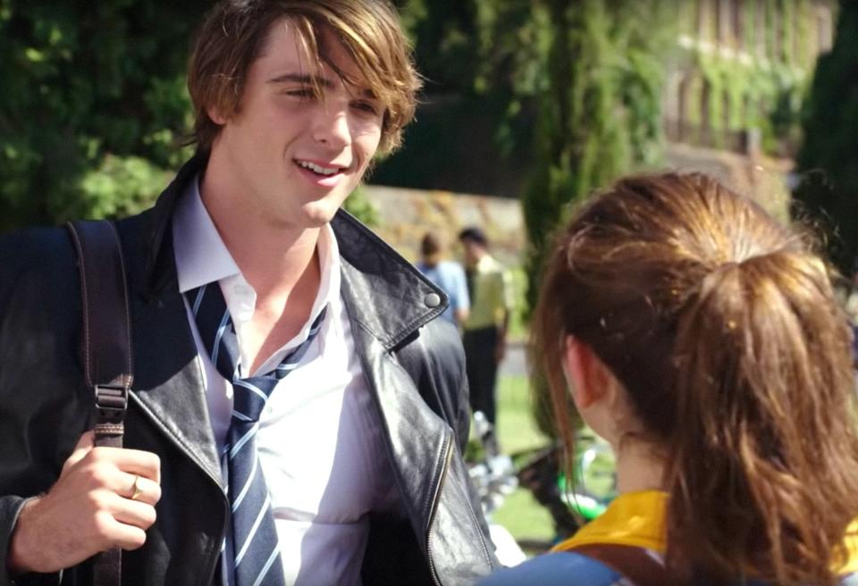 Jacob Elordi smiling and talknig to a girl on campus in "The Kissing Booth"