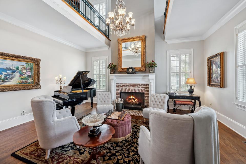 A sitting room with large chandeliers and balconies overlooking it.