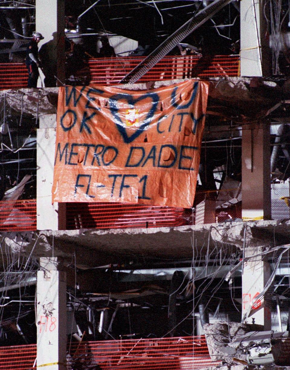 FILE - In this April 30, 1995, file photo, a banner placed by the Dade County (Fla.) search and rescue team, saying "We Love You Oklahoma City," hangs from a floor of the bomb-devastated Alfred P. Murrah Federal Building in Oklahoma City. The team assisted in the search for victims of the attack. Search and rescue teams from Miami-Dade have been described as among the best and most experienced in the world. (AP Photo/Amy Sancetta, File)