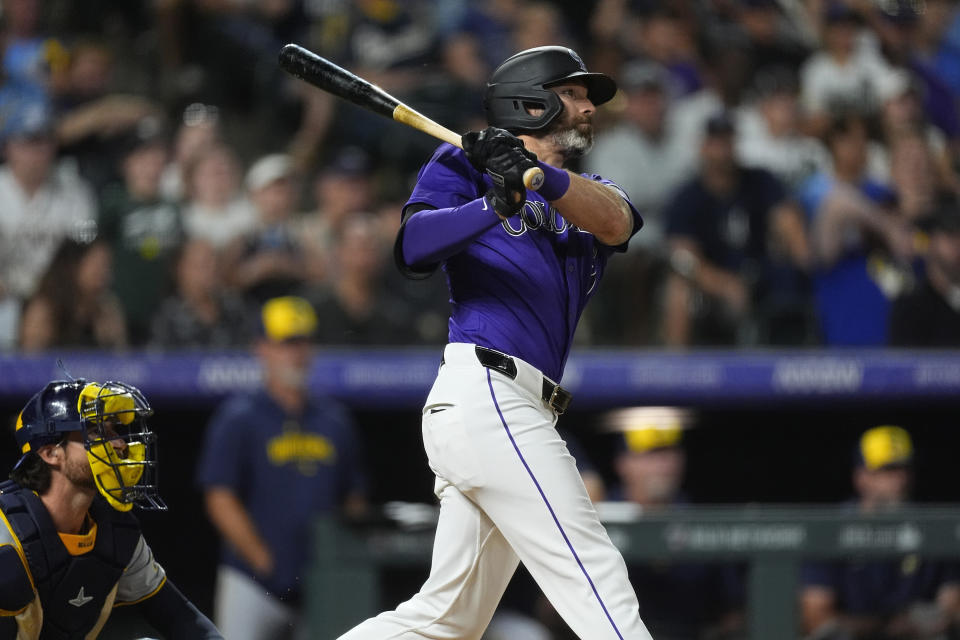 Colorado Rockies' Jake Cave, right, follows the flight of his walkoff RBI single off Milwaukee Brewers relief pitcher Joel Payamps in the 10th inning of a baseball game Monday, July 1, 2024, in Denver. (AP Photo/David Zalubowski)