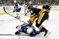 Pittsburgh Penguins' Brock McGinn (23) checks Winnipeg Jets' Neal Pionk (4) during the second period of an NHL hockey game in Pittsburgh, Sunday, Jan. 23, 2022. (AP Photo/Gene J. Puskar)