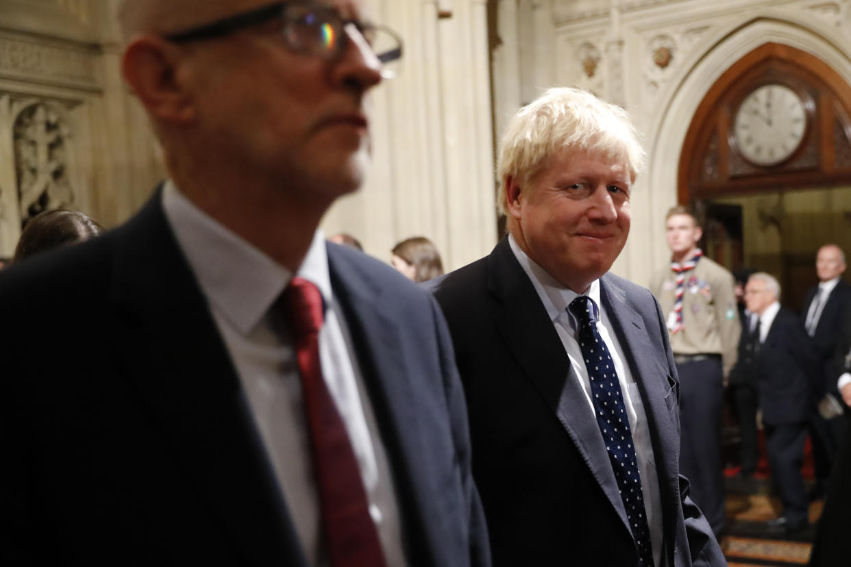 LONDON, ENGLAND - OCTOBER 14: British Prime Minister Boris Johnson (R) smiles as walks back through the Peers Lobby next to Britain's main opposition Labour Party leader Jeremy Corbyn (L) after listening to the Queen's Speech during the State Opening of Parliament in the Houses of Parliament on October 14, 2019 in London, England. The Queen's speech is expected to announce plans to end the free movement of EU citizens to the UK after Brexit, new laws on crime, health and the environment. (Photo by Tolga Akmen - WPA Pool/Getty Images)