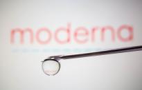 Moderna's logo is reflected in a drop on a syringe needle in this illustration