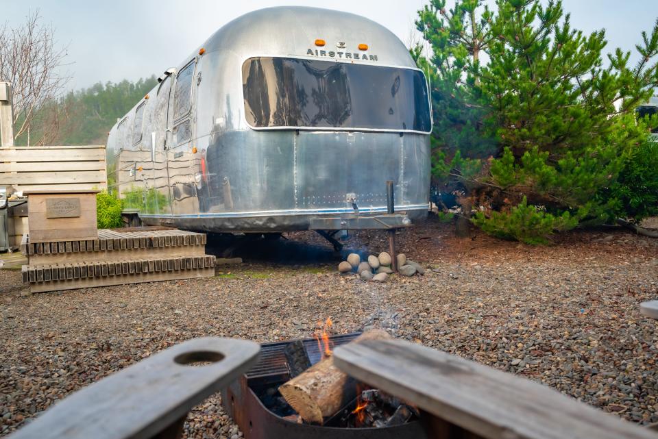 Silver airstream next to a tree