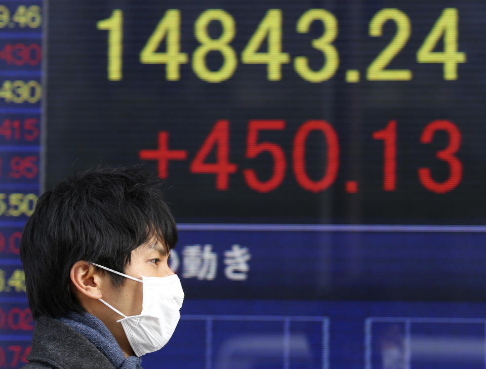 A man walks past an electronic stock board of a securities firm in Tokyo,Tuesday, Feb. 18, 2014. Japan led Asian stock markets higher Tuesday after the country's central bank announced new measures to support growth. The Nikkei 225 in Tokyo was up 3.1 percent at 14,843.24 after the Bank of Japan said it was doubling the size of its fund to support bank lending and its fund to support economic growth. The funds, which were due to expire shortly, were extended for another year. (AP Photo/Koji Sasahara)