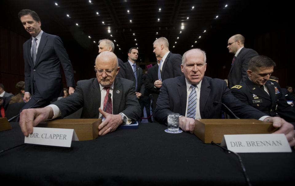 Director of National Intelligence James Clapper, foreground left, and CIA Director John Brennan, foreground right, take their seats on Capitol Hill in Washington, Wednesday, Jan. 29, 2014, prior to testifying before the Senate Intelligence Committee hearing on current and projected national security threats against the U.S. Also taking their seats on the panel are Defense Intelligence Agency Director Lt. Gen. Michael Flynn, far right, and FBI Director James Comey, far left. (AP Photo/Pablo Martinez Monsivais)