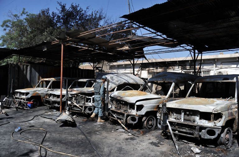 An Afghan policeman inspects the burnt out wreckage of vehicles of the International Committee of the Red Cross after an attack in Jalalabad on May 30, 2013. The Taliban on Friday denied any involvement in a deadly suicide attack on International Committee of the Red Cross offices that prompted the organisation to halt staff movement across Afghanistan