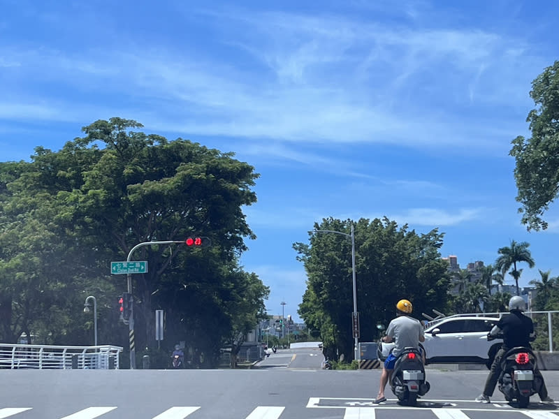 夏季高溫  高雄交通局縮短號誌秒數 夏季酷熱，機車騎士停紅燈常躲樹蔭下，高雄市交通 局7月起中午時段逐步調整縮短部分號誌週期秒數， 減少停等時間。 中央社記者林巧璉攝  113年7月12日 