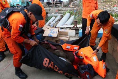 Search and rescue officers carry items they believe belonged to passengers from a ferry which sank last week in Lake Toba, at Tigaras Port, Simalungun, North Sumatra, Indonesia June 25, 2018 in this photo taken by Antara Foto. Picture taken June 25, 2018. Irsan Mulyadi/Antara Foto via REUTERS