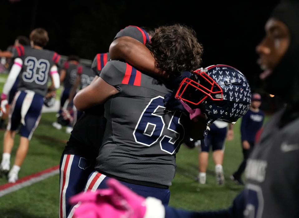 Hartley's James Sewell (65) embraces Donovan Davis after a 15-12 win over DeSales on Friday.