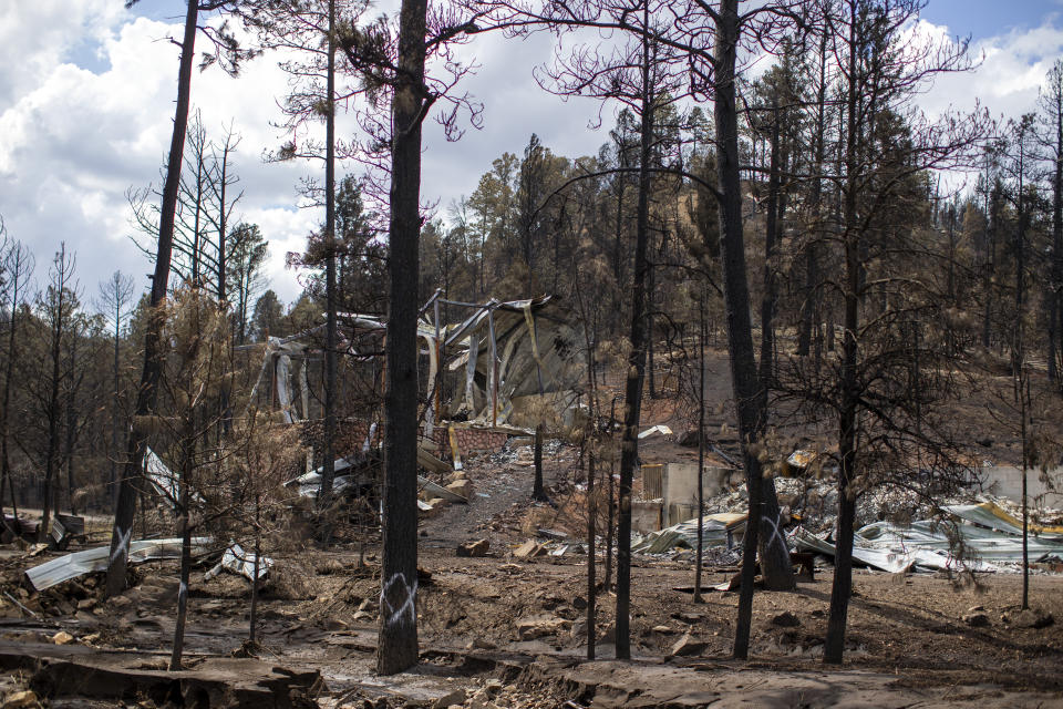 The remains of a house destroyed by the South Fork Fire are pictured in the mountain village of Ruidoso, N.M., Saturday, June 22, 2024. (AP Photo/Andres Leighton)