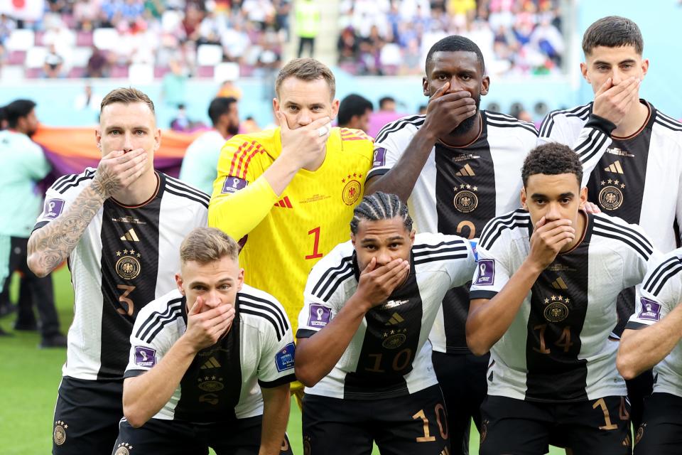 Germany players pose with their hands covering their mouths as they line up for the team photos prior to the FIFA World Cup Qatar 2022 Group E match between Germany and Japan at Khalifa International Stadium.