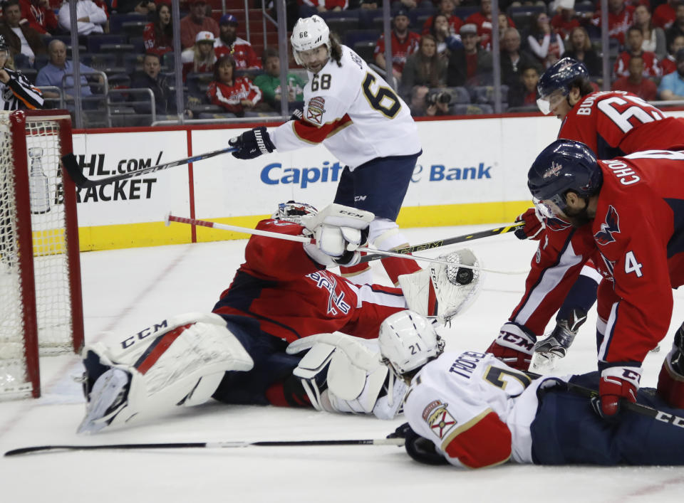 Washington Capitals goalie Braden Holtby (70) makes a save as he catches the puck hit by Florida Panthers center Vincent Trocheck (21) during the first period of an NHL hockey game in Washington, Sunday, April 9, 2017. (AP Photo/Manuel Balce Ceneta)