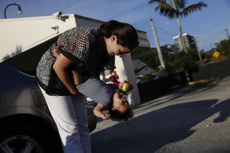 Veronika Leniz, 26, a Venezuelan single mother, plays with her daughter Ainara after picking her up from the daycare in Miami April 28, 2014. REUTERS/Carlos Garcia Rawlins