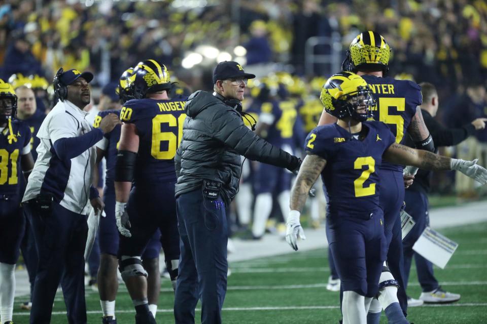 Michigan coach Jim Harbaugh meets players after a touchdown against Purdue during the second half of Michigan's 41-13 win on Saturday, Nov 4, 2023, in Ann Arbor.