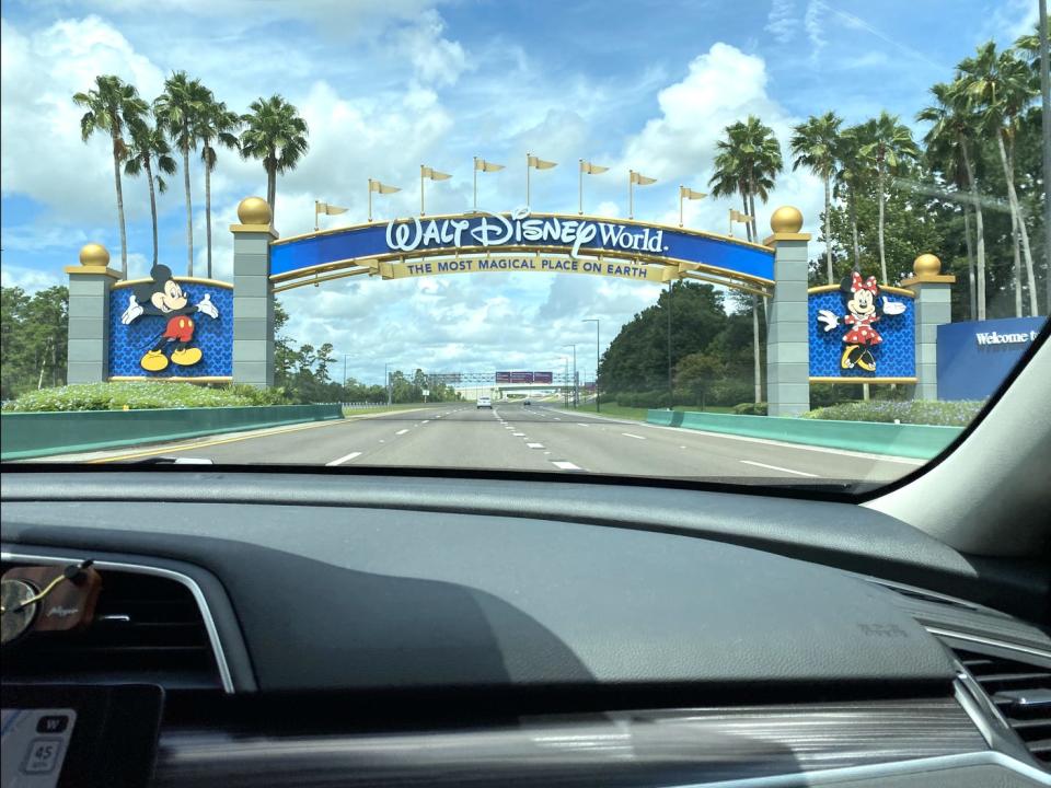 A photo of Disney World's entrance gates taken from a car.