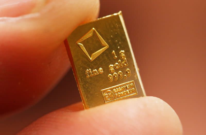 FILE PHOTO: An employee shows a 1 gram piece of a gold Combibar at a plant of gold refiner and bar manufacturer Valcambi SA in the southern Swiss town of Balerna