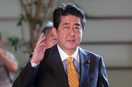 Japanese Prime Minister Shinzo Abe waves to the media upon his arrival at his official residence in Tokyo, Japan September 18, 2018. Eugene Hoshiko/Pool via Reuters