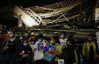 Family members protest demanding justice for the people who died in Monday's subway collapse, at the site of the wreckage in Mexico City's south side, Friday, May 7, 2021. An elevated section of Line 12 collapsed late Monday killing at least 25 people and injuring more than 70, city officials said. (AP Photo/Eduardo Verdugo)