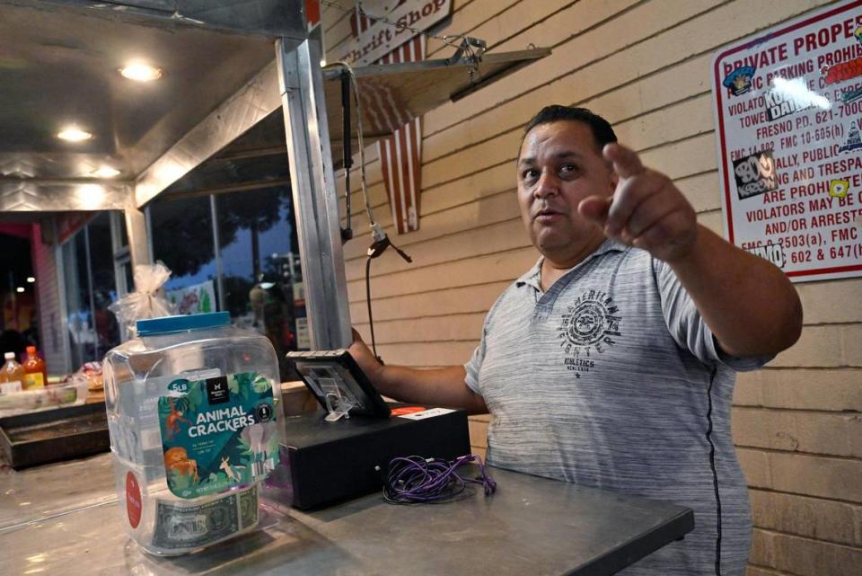 Jaime Gómez, a food vendor selling hot dogs, sets up shop on the sidewalk along Olive Avenue in Fresno’s Tower District Wednesday evening, July 19, 2023.