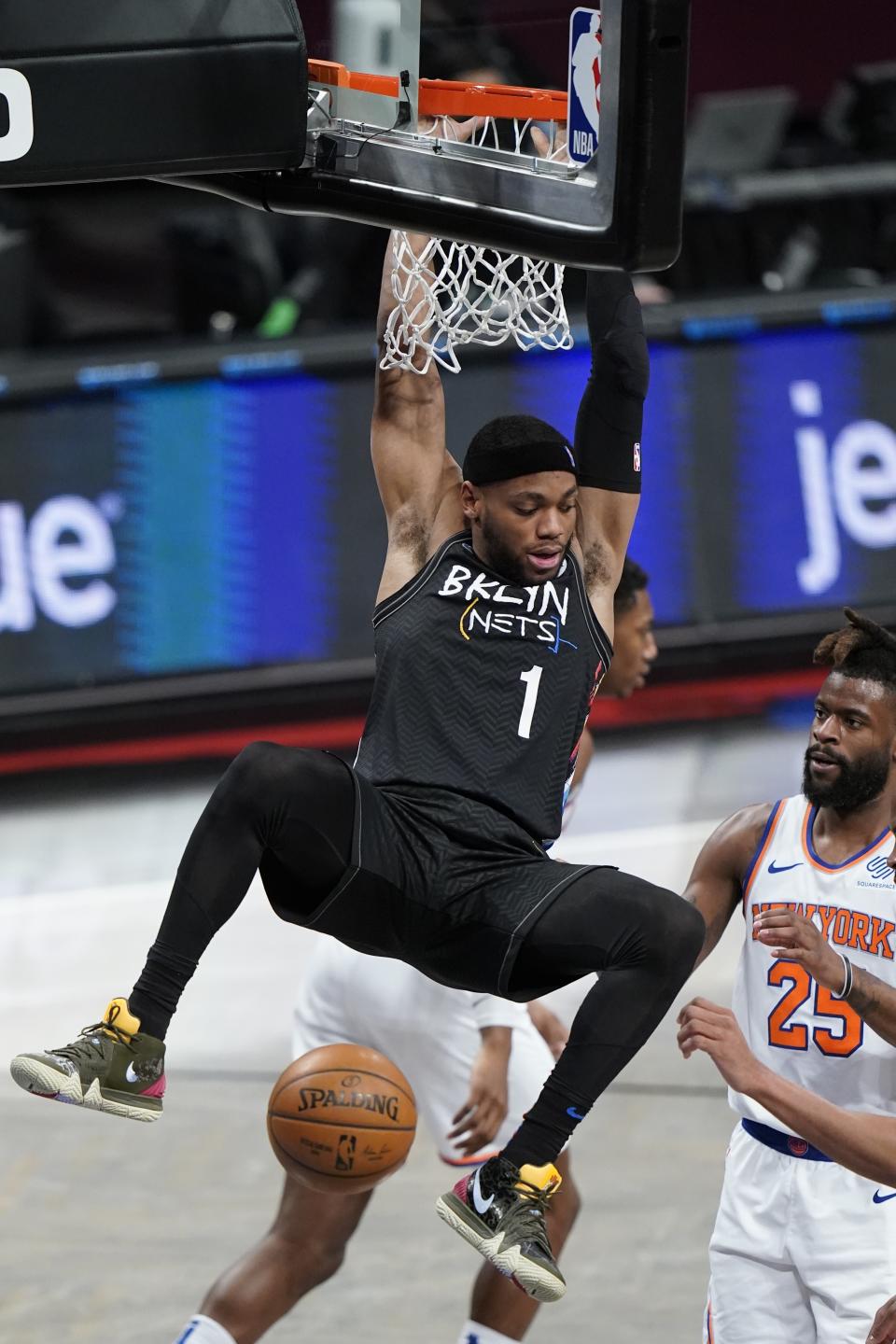 Brooklyn Nets' Bruce Brown (1) dunks the ball in front of New York Knicks' Reggie Bullock (25) during the first half of an NBA basketball game Monday, April 5, 2021, in New York. (AP Photo/Frank Franklin II)