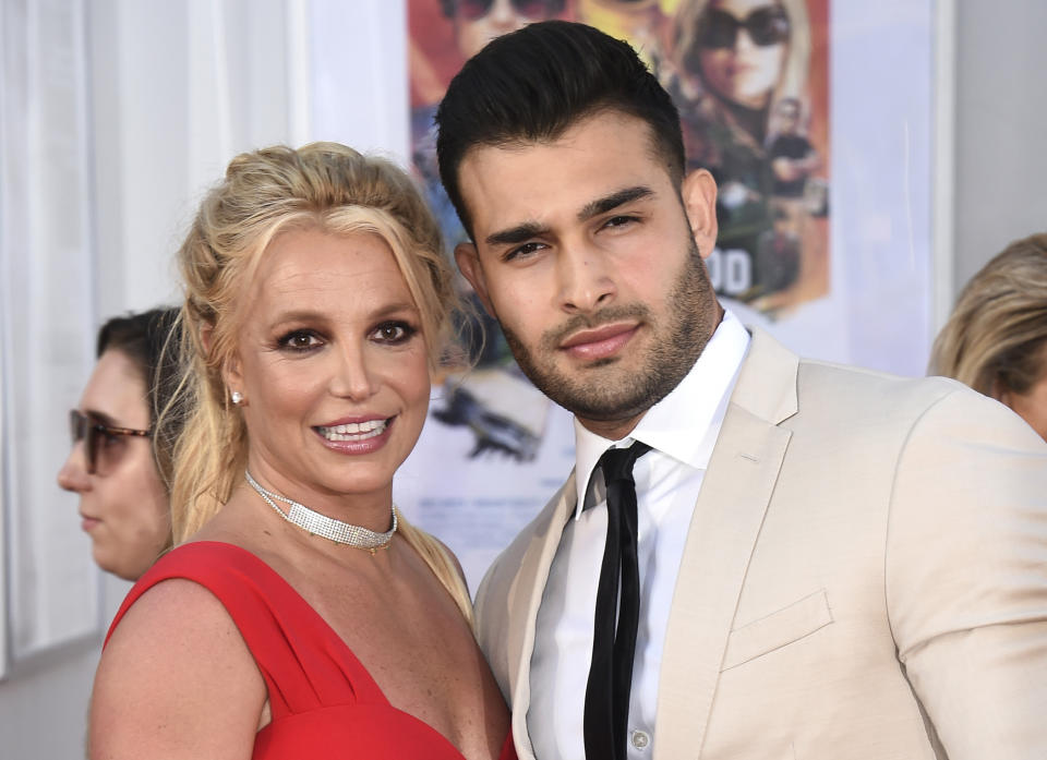 FILE - Britney Spears and Sam Asghari appear at the Los Angeles premiere of "Once Upon a Time in Hollywood" on July 22, 2019. Spears has reached a divorce settlement with her soon-to-be-ex-husband Asghari. (Photo by Jordan Strauss/Invision/AP, File)