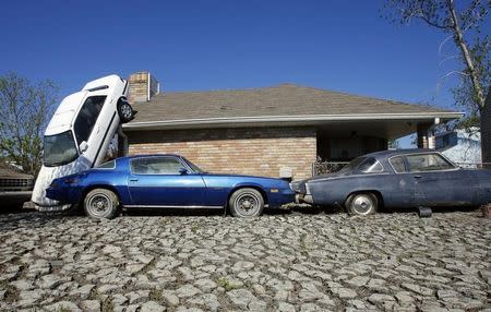 An automobile is left leaning, almost vertically, against a house by 12-foot floodwaters in St. Bernard Parish, east of New Orleans, Louisiana October 9, 2005. REUTERS/Lucas Jackson