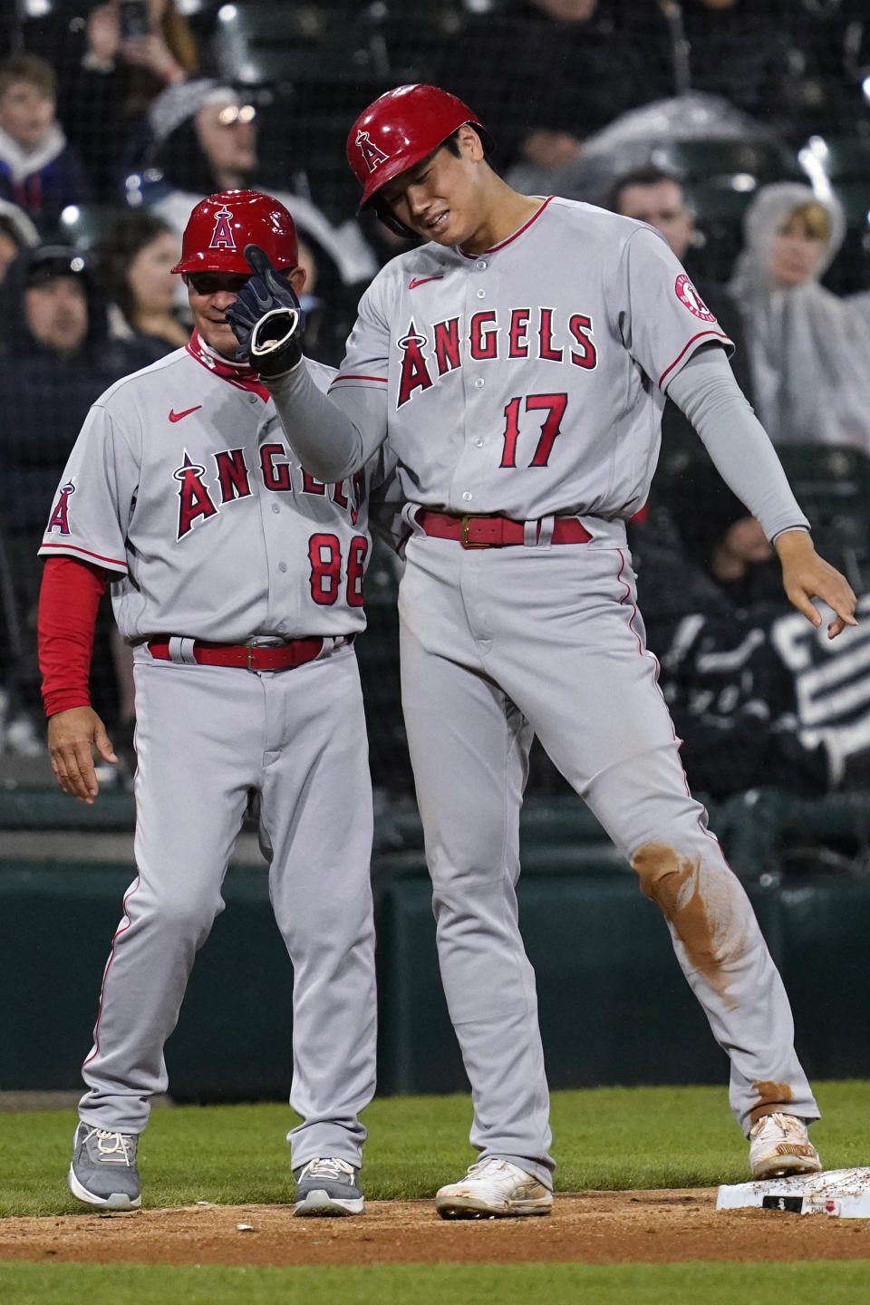 Los Angeles Angels' Shohei Ohtani, right, of Japan, talks to third base coach Phil Nevin at third during the eighth inning of a baseball game against the Chicago White Sox in Chicago, Friday, April 29, 2022. (AP Photo/Nam Y. Huh)